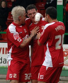 Sean Morrison is congratulated by Lee Peacock and Billy Paynter after the 17-year-old put Swindon one-nil up