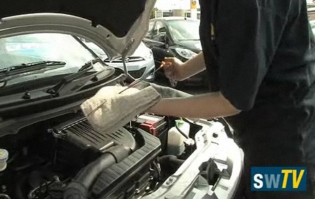 Checking the oil dipstick at Pebley Beach garage, Swindon